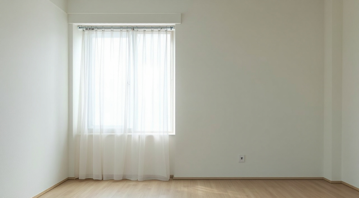 賃貸住宅の室内。窓の上に取り付けられたカーテンレールとレースカーテン